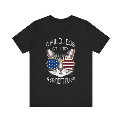 "Unisex tee with 'Childless cat lady & student nurse' and artwork of a cat in USA color glasses. Lightweight cotton, ribbed collar, crew neckline. Free USA shipping."